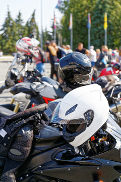 Moto helmets on motorcycles and motorbikes on blurred background