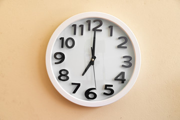 Wall clock on cream color background.
