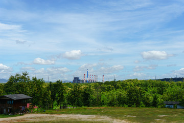 Fototapeta na wymiar panorama view of coal fired power plant in the forest with blue sky and cloud and Abandoned house.