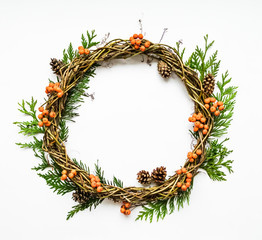 Festive wreath of vines with thuja branches, rowanberries and cones. Flat lay, top view