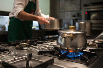 A chef cooking over the stoves