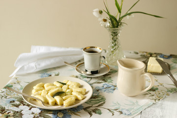 Homemade cottage cheese gnocchi or vareniki with sage oil. Useful breakfast. Gnocchi, coffee, milk. Rustic style, selective focus.