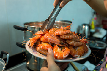 Picking steamed shrimp out ot the pot