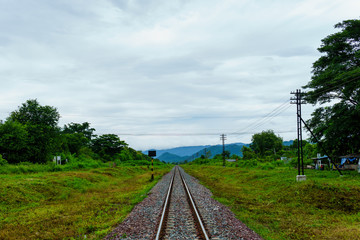 Fototapeta premium landscape view of railway track heading into the valley with cloudy sky