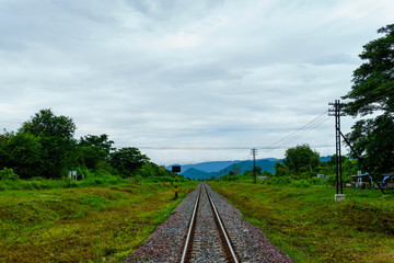Fototapeta na wymiar landscape view of railway track heading into the valley with cloudy sky