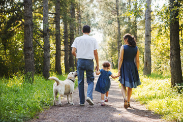 Fototapeta premium Happy family with dog walking in the Park