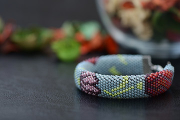 Bead crochet bracelet gray color with flower print close up