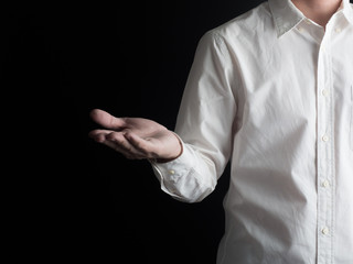 Young man giving empty hand on black background.Hands open businessman. some object are here.