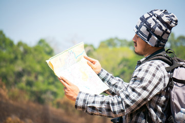 Traveler looking to map on the way in forest