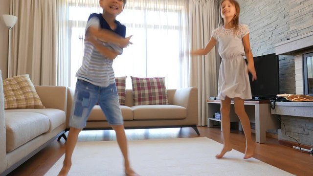 The children are having fun. The boy and the girl are having fun. The children are dancing. The children are jumping.