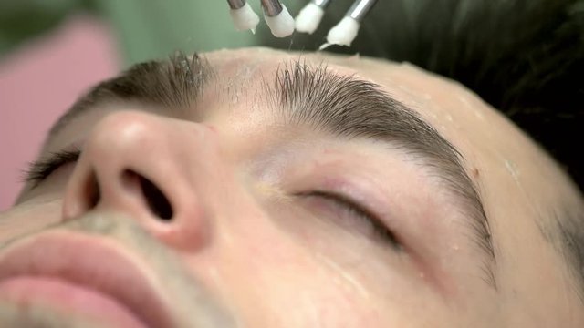 Close up of microcurrent therapy. Face of a man, cosmetology. Modern methods of skin treatment.