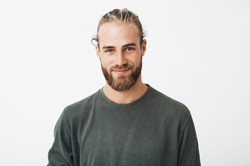 Portrait of beautiful mature blonde bearded guy with trendy hairdo in casual grey shirt smiling and...