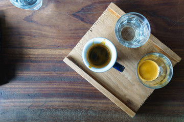 top view of ristretto and espresso shot in the cup and transparent glass on the wooden and plate and table.