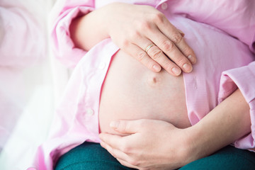 Pregnant girl hugging her belly