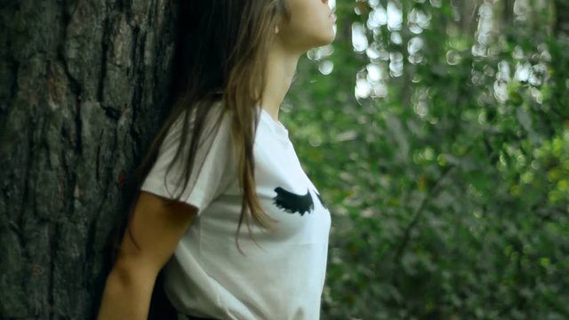 sensual girl with her eyes closed stands near the tree the forest