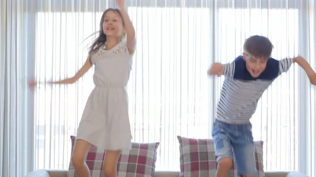 The children are having fun. The boy and the girl are having fun. The children are dancing. The children are jumping.