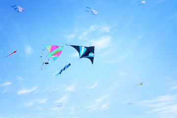 Colorful kite flying in the blue sky through the clouds