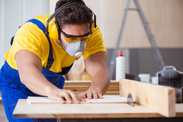 Young repairman carpenter working with a circular saw