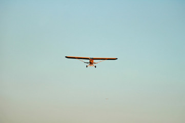 small yellow airplane head on in the landing cue
