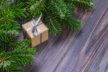 Fototapeta na wymiar Christmas background with Christmas gift on wooden background with Fir branches. Xmas and Happy New Year composition. Flat lay, top view