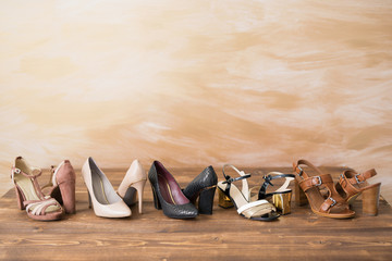 Diferent style woman's high heels on wooden floor