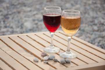 Two wineglass with red, white wine stand on table near in afternoon