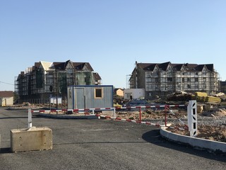 Gate to restrict entrance to the construction site. Construction of multi-storey apartment buildings in the summer