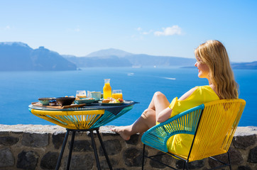 Woman enjoying luxurious breakfast with beautiful view from terrace