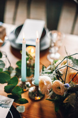 decorated plates with boards of cheese, baskets of bread, candles, candlesticks, flowers, bouquet, jam.