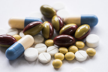 Close-up of a heap of colourful pills on white background