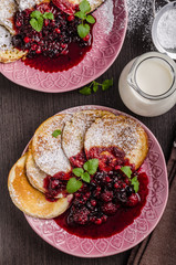 Obraz na płótnie Canvas Crepes pancakes with berries reduction