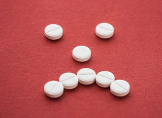 Close-up of a heap of colourful pills on white background