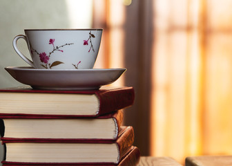 Several books and a cup of coffee on the table.