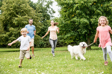 Kinder laufen mit Retriever Hund