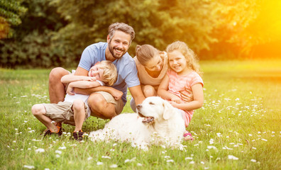 Familie und Kinder mit Hund im Garten