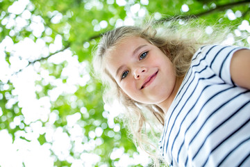 Blondes Mädchen lächelt im Frühling