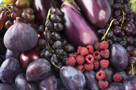 Purple food. Background of berries, fruits and vegetables. Fresh figs, plums, raspberries, eggplant and grapes. Top view