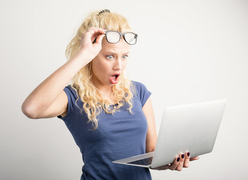 Woman in shock looking at laptop