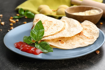 Plate with delicious tortillas on kitchen table