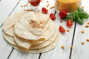 Delicious tortillas on wooden table