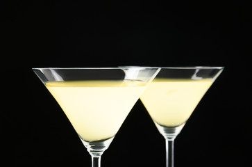 Glasses of lemon drop martini on black background