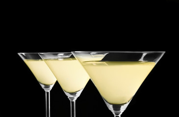 Glasses of lemon drop martini on black background
