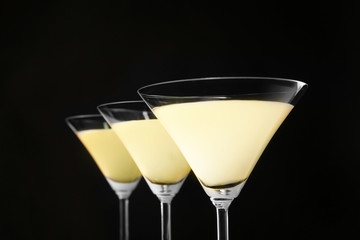 Glasses of lemon drop martini on black background