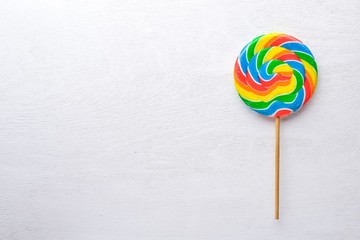 Colored candies, sweets and lollipops. On a white wooden background. Top view. Free space.