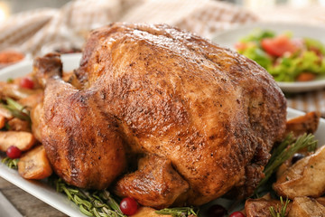 Tasty roasted turkey with potatoes on plate