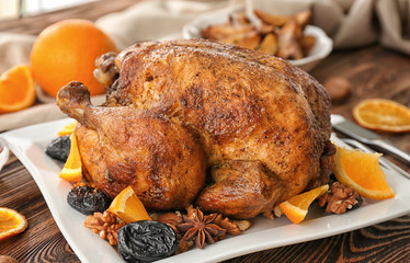 Tasty roasted turkey with slices of orange and prune on plate