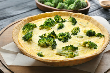 Tasty broccoli quiche on wooden board