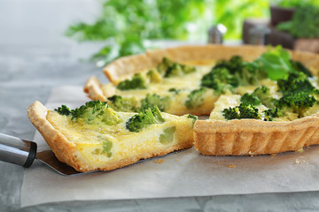 Piece of tasty broccoli quiche on table