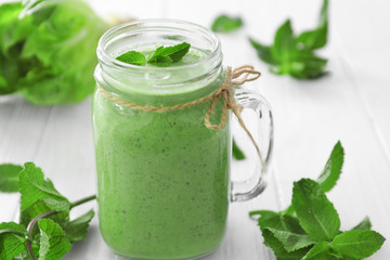 Healthy smoothie with kale in mason jar on wooden table