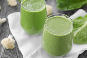 Healthy smoothie with kale in glasses on table